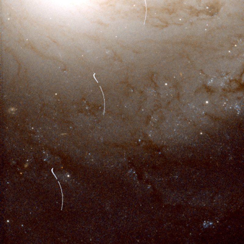 这个残断的小行星轨迹穿过了M91星系的外围。小行星进入图像的顶部中心，并向左下方移动。因为哈勃绕着地球转，它不能不停地盯着这个星系。所以留下了中断的踪迹。图片：NASA/ESA