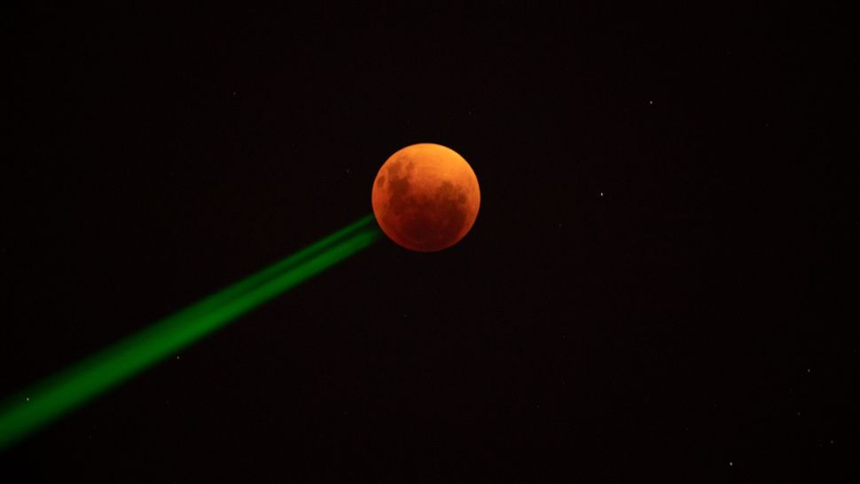 当地时间2022年5月15日，在圣地亚哥看到的半影月食血月。(图片来源: Martin Bernetti/AFP)